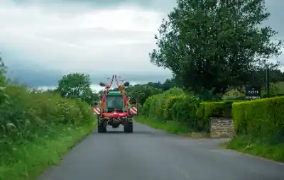 Tractor with rake clearing scrub and brush | Elite Tree Surgeons Telford