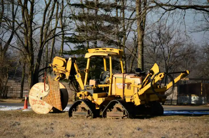 Yellow bulldozer standing in field | Elite Tree Surgeons Telford